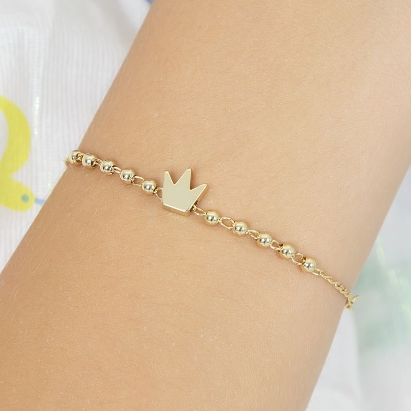 PULSEIRA INFANTIL DE BOLINHAS E UMA COROA DOURADA NO CENTRO