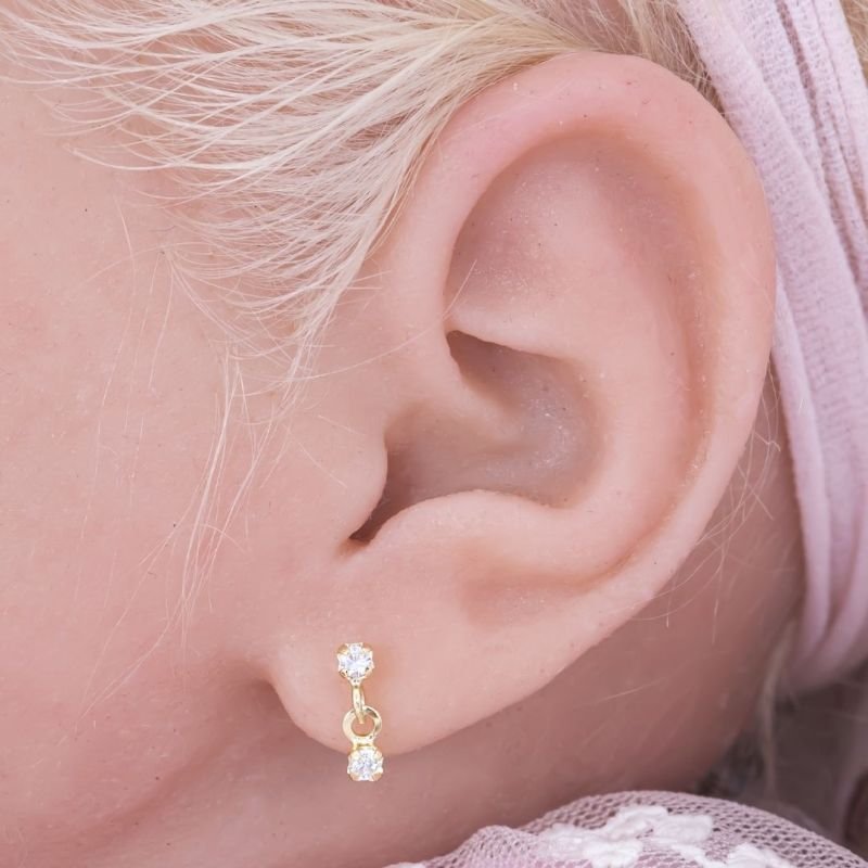 BRINCO BEBÊ DUAS PEDRINHAS CRAVEJADAS BANHADO EM OURO